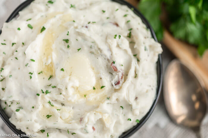 Close up image of ranch mashed potatoes in a black bowl. 