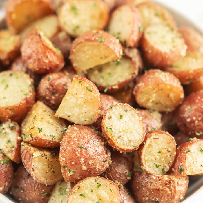 Serving dish of roasted red potatoes.