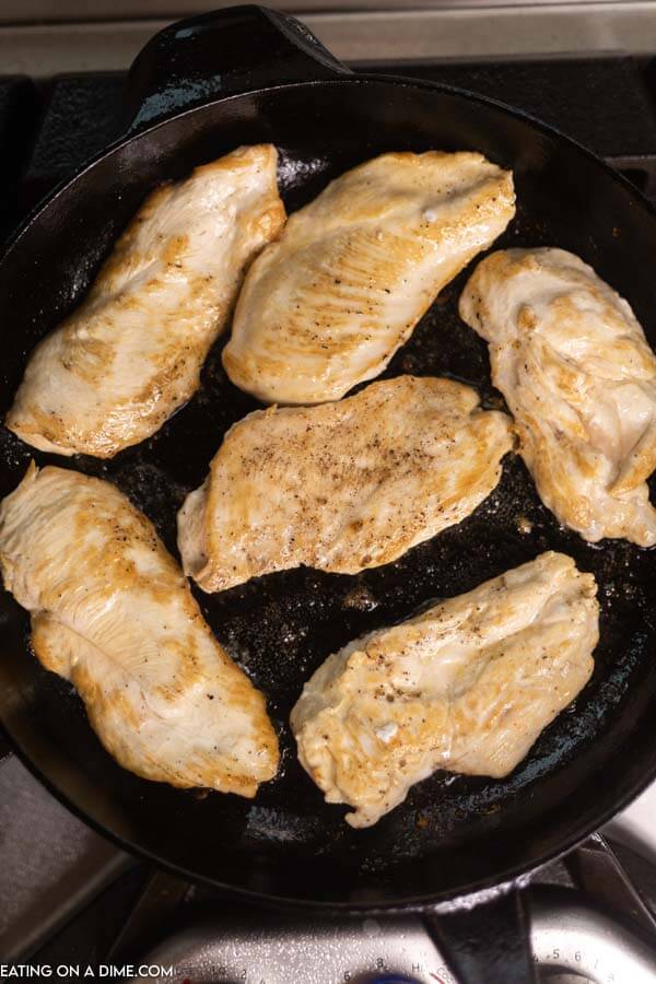 6 Chicken Breasts browned in a cast iron skillet 