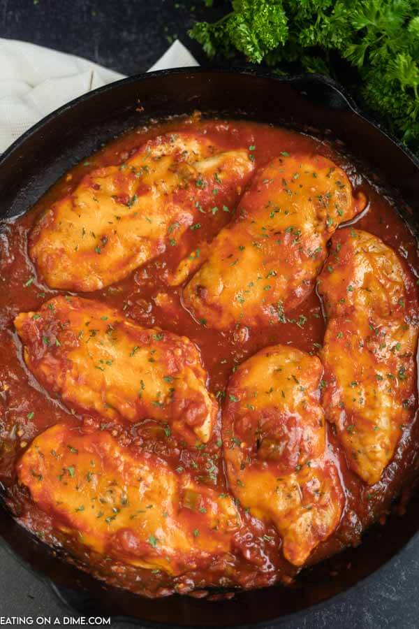 6 Salsa Chicken Breasts topped with cheese in a cast iron skillet 