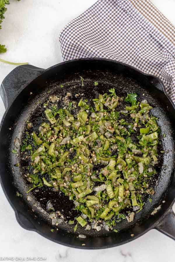 Close up image of herbs and onion in iron skillet