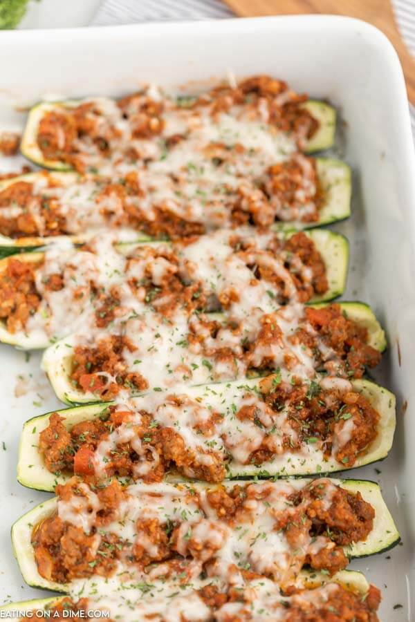 Baking pan of stuffed zucchini boats baked with cheese. 