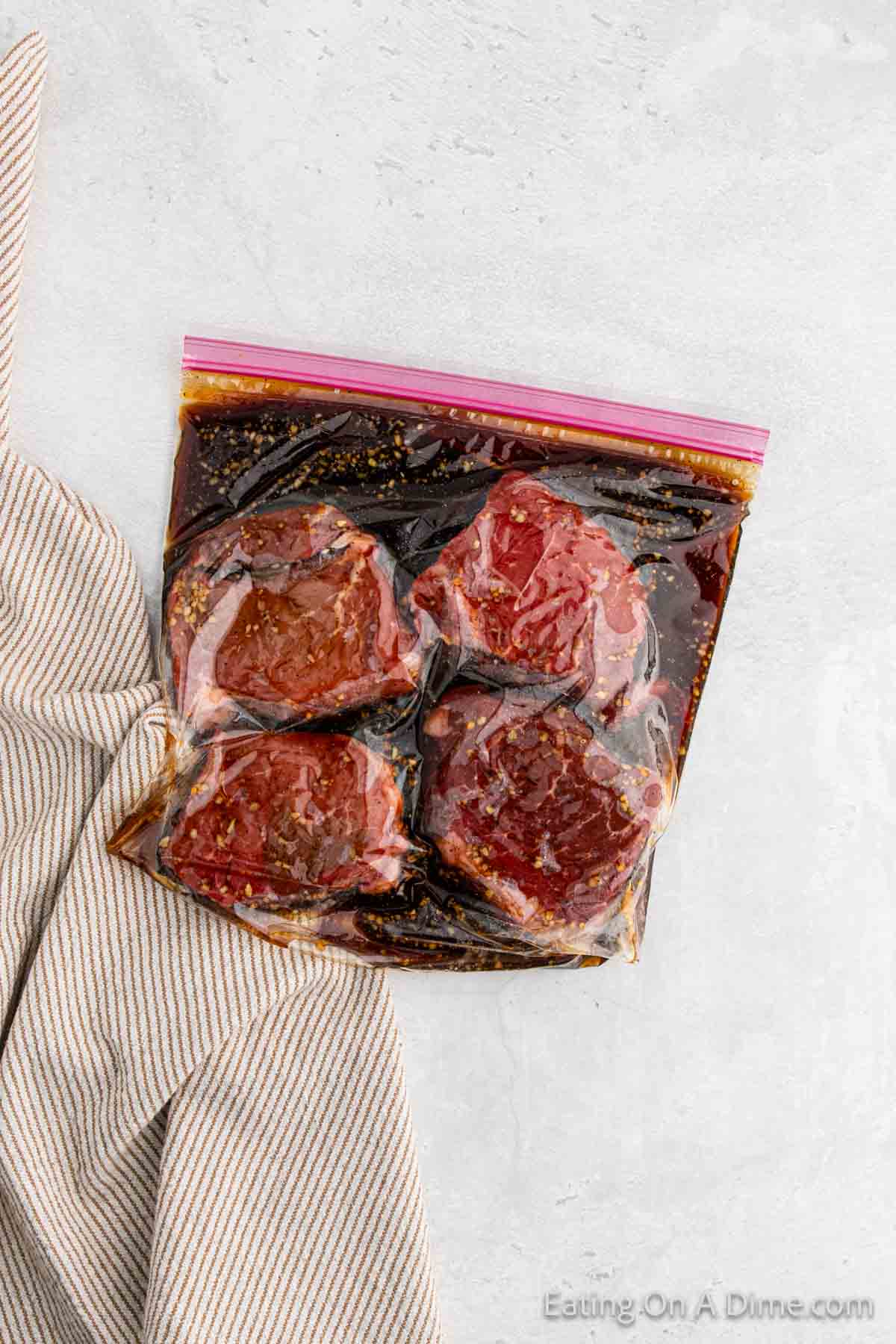 Marinating steak in a zip lock bag with the marinade