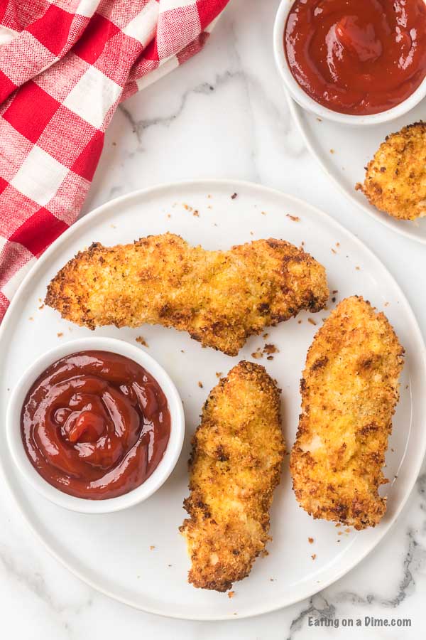 Air Fryer Chicken tenders on a plate with ketchup for dipping. 