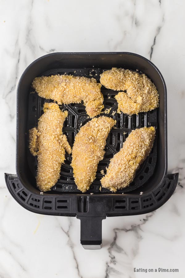 Chicken tenders in air fryer basket ready to be cooked. 