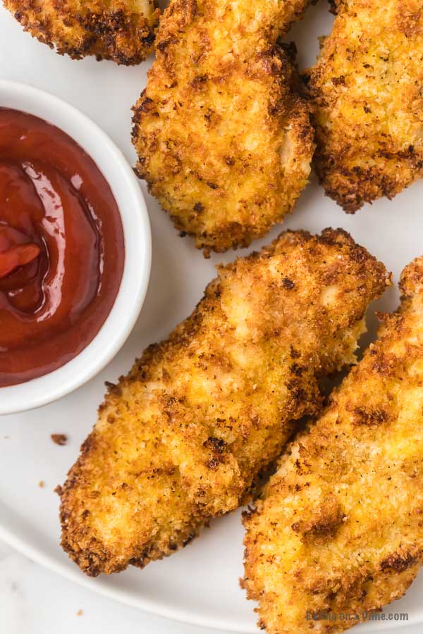 Air Fryer Chicken tenders on a plate with ketchup for dipping. 