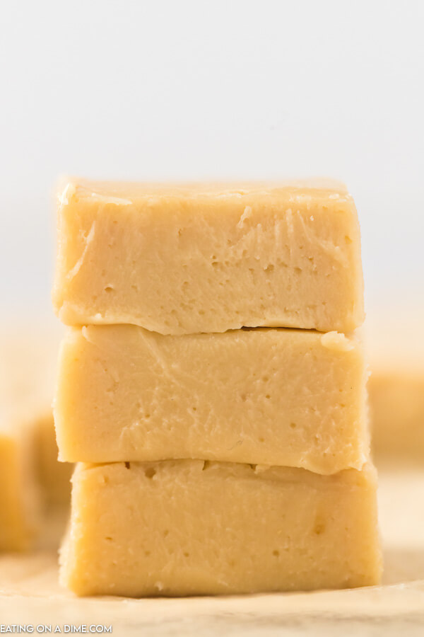 Close up of pieces of caramel fudge stacked on top of each other. 