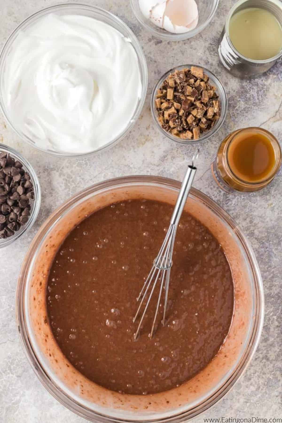 Combining the cake mix ingredients in a bowl with a whisk.
