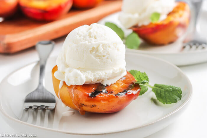 grilled peach topped with ice cream on a plate