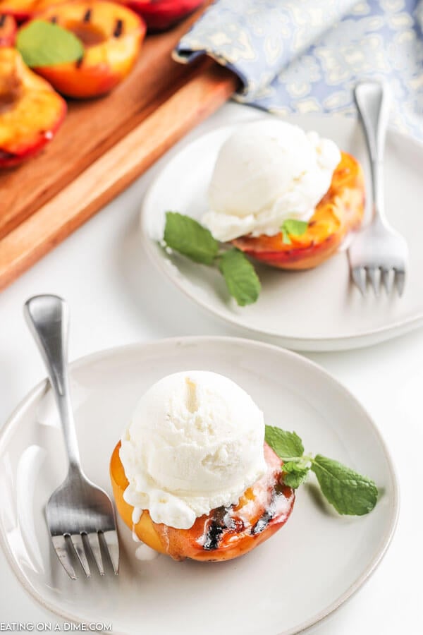 grilled peach topped with ice cream on a plate