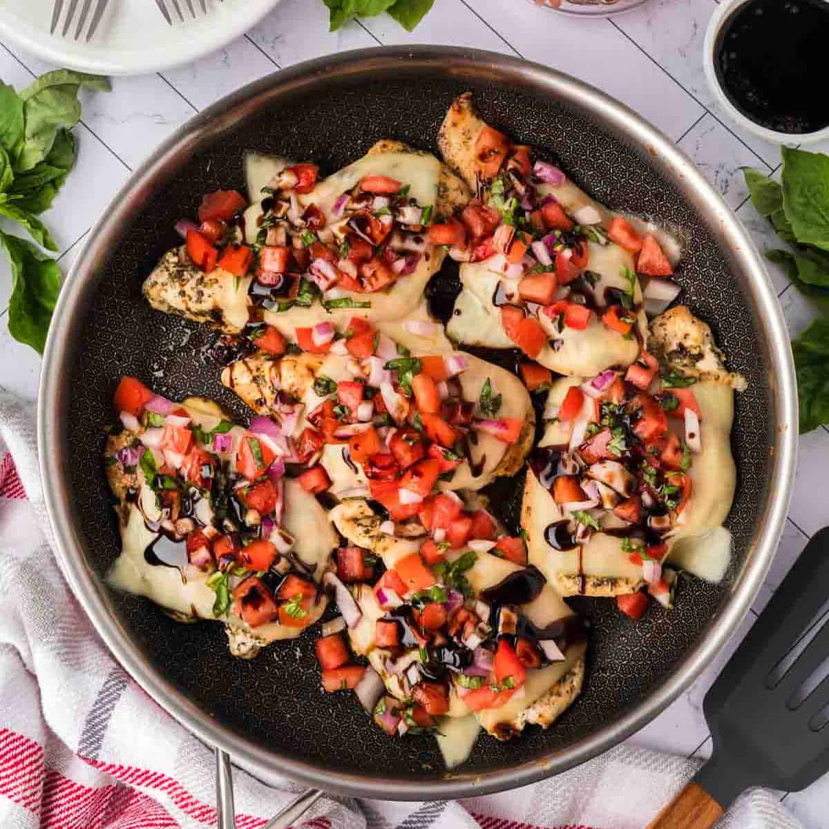 A skillet filled with chicken and tomatoes.