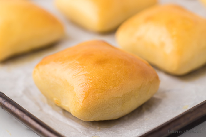 Copycat Texas rolls on a baking sheet lined with wax paper. 