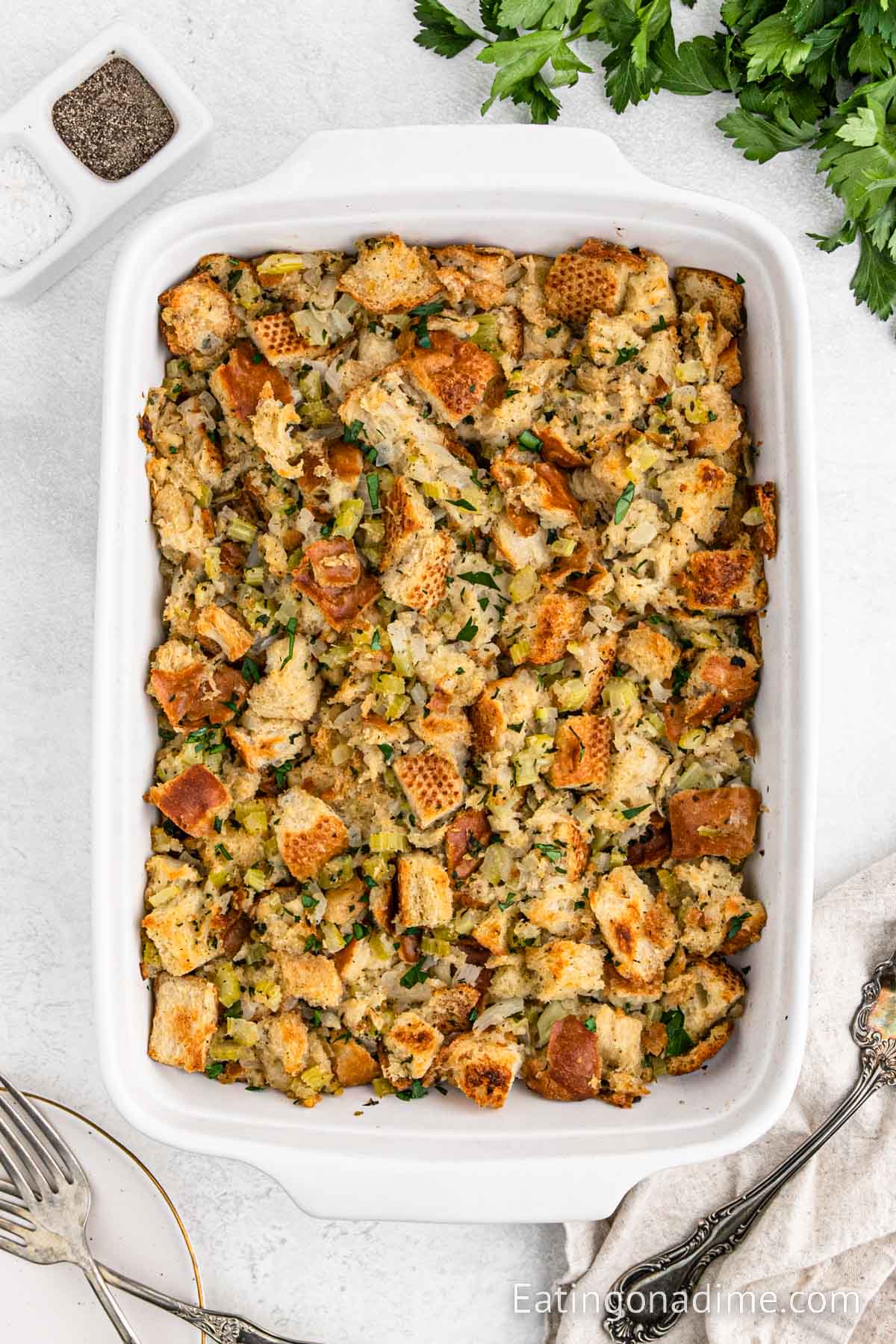 The homemade stuffing in a casserole dish - baked and topped with fresh chopped parsley.  