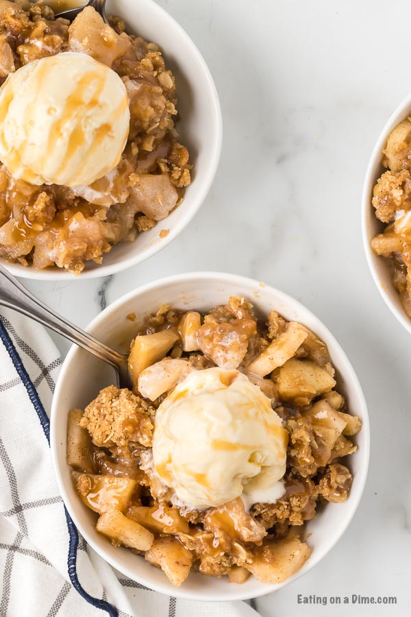 several bowls of apple crisp with ice cream and caramel sauce