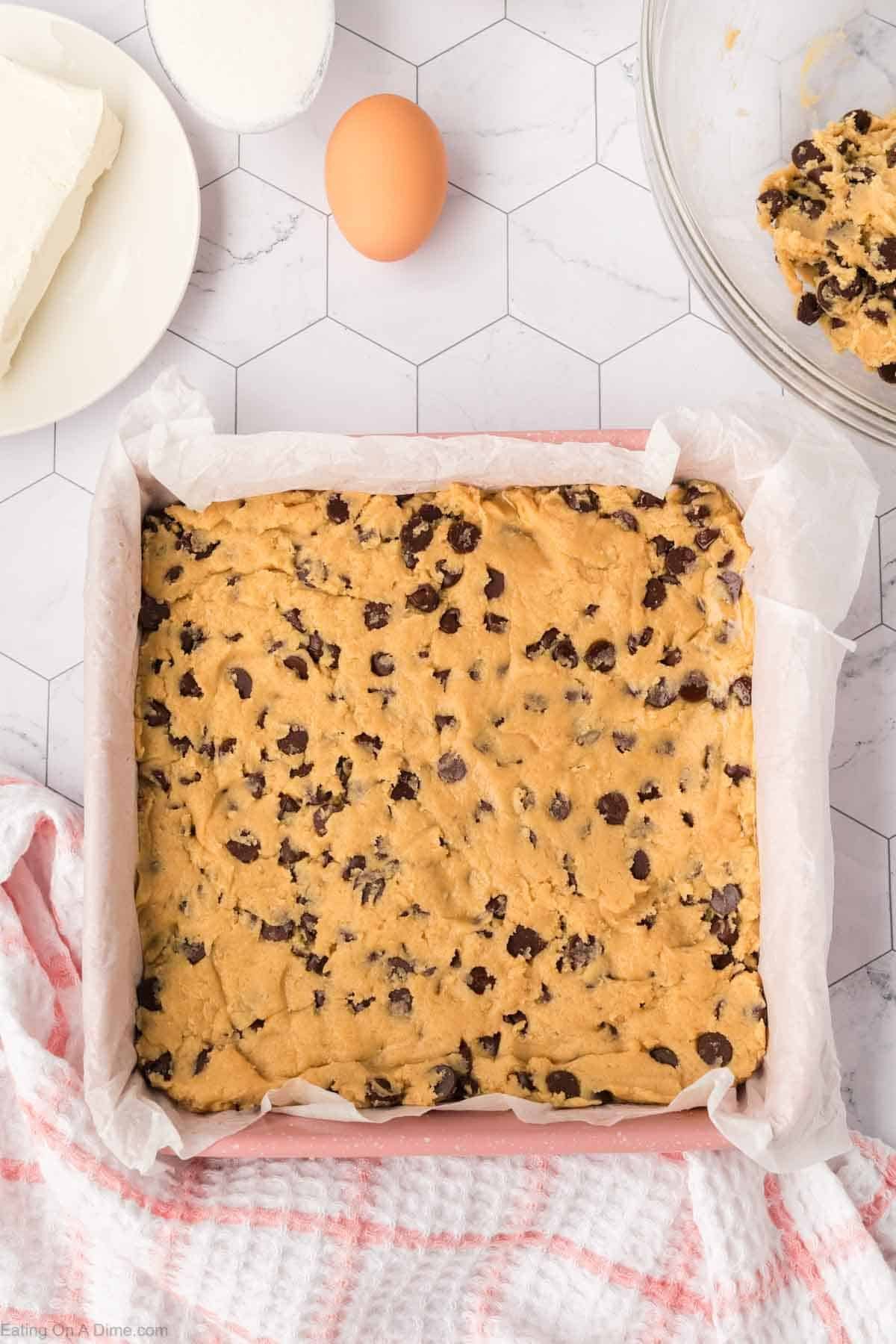 Chocolate Chip Cookie Dough pressed into a square pan lined with parchment paper