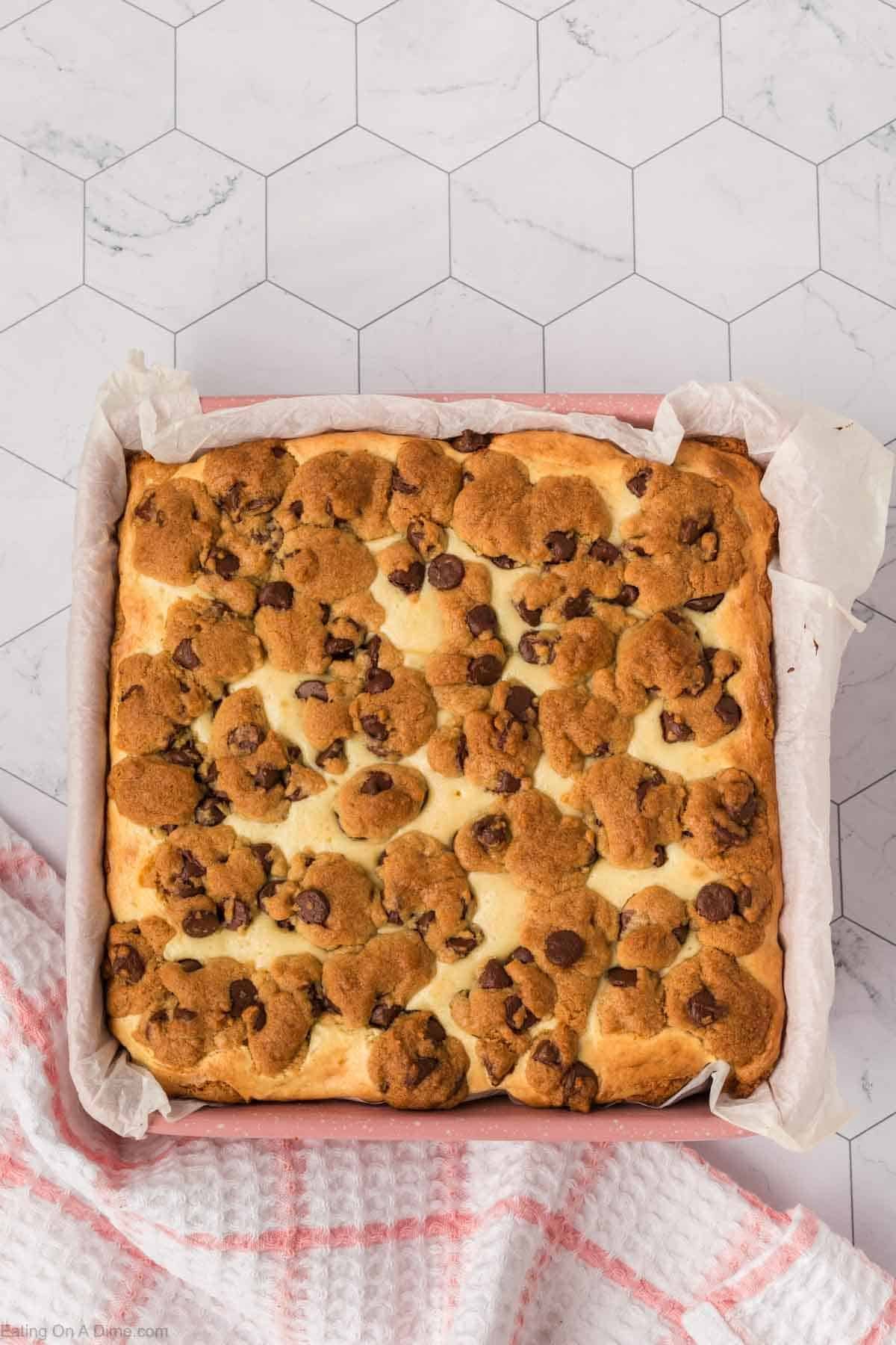 Baked Chocolate Chip Cheesecake in a baking pan lined with parchment paper