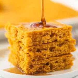 Baked Pumpkin Pancakes stacked together on a white plate.