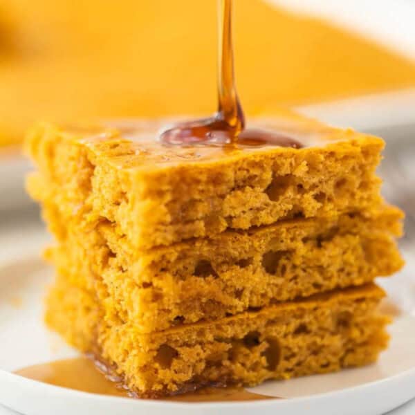 Baked Pumpkin Pancakes stacked together on a white plate.