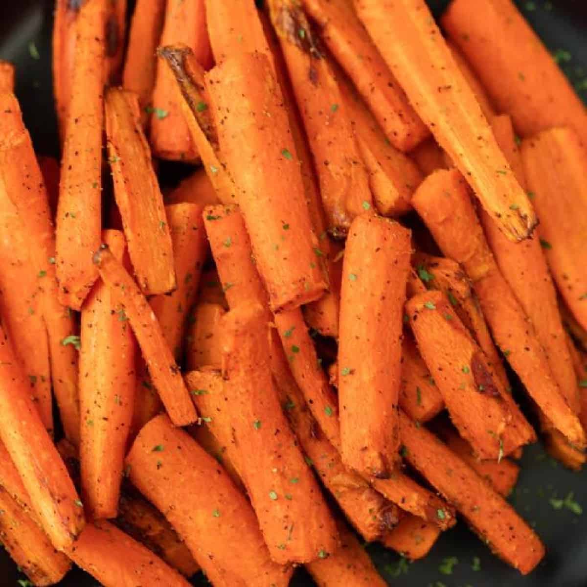 Air fryer carrots on a black plate ready to serve.