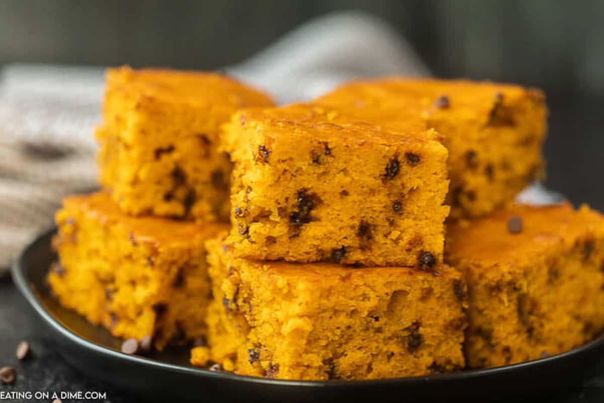 Delicious and most pumpkin chocolate chip bars cut and stacked on top of each other on a serving plate.  