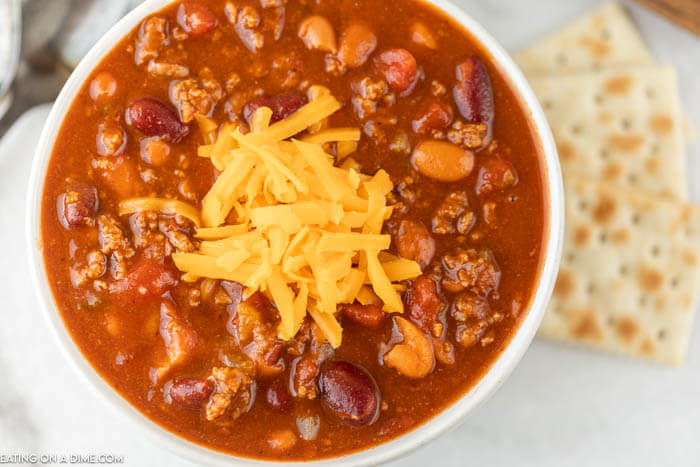 Close up image of a white bowl of wendy's chili and a side of crackers. 