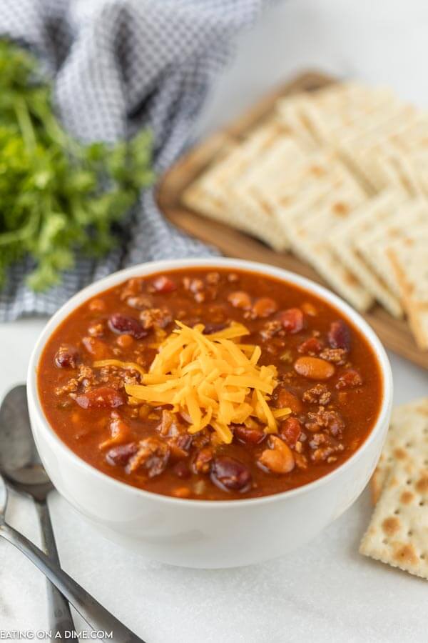 Close up image of a bowl of Wendy's Chili topped with cheese and a side of saltine crackers. 