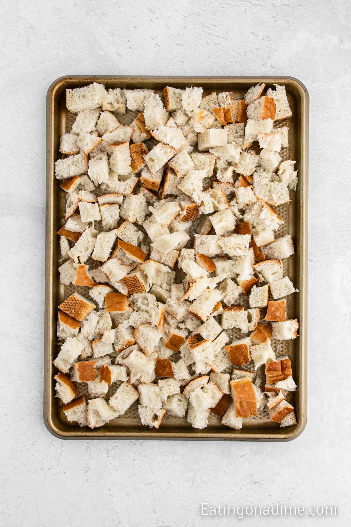 Placing the diced bread on a baking sheet