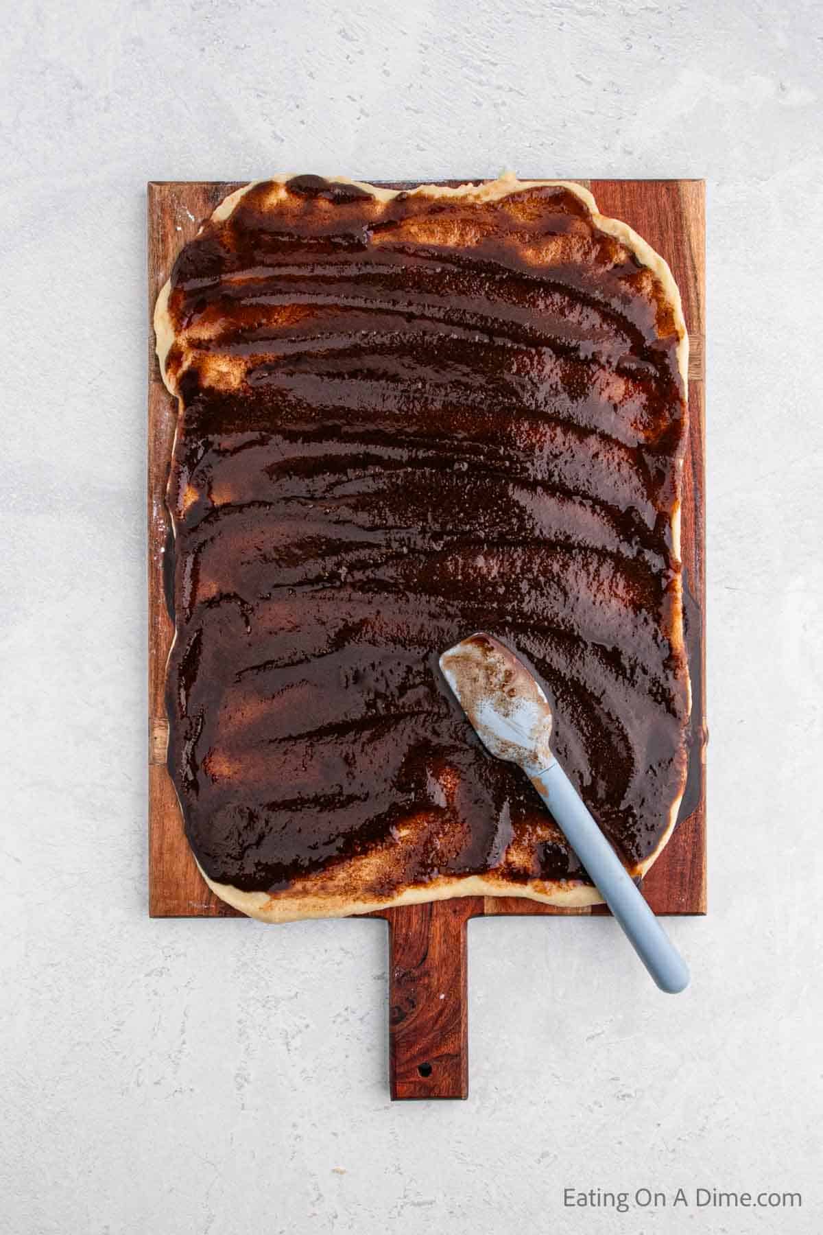 Spreading the cinnamon sugar filling mixture on the dough with a spatula