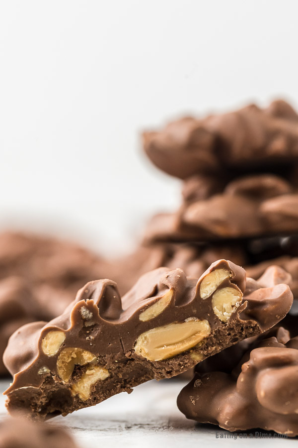 Close up image of peanut clusters in half so you can see the peanuts and chocolate. 