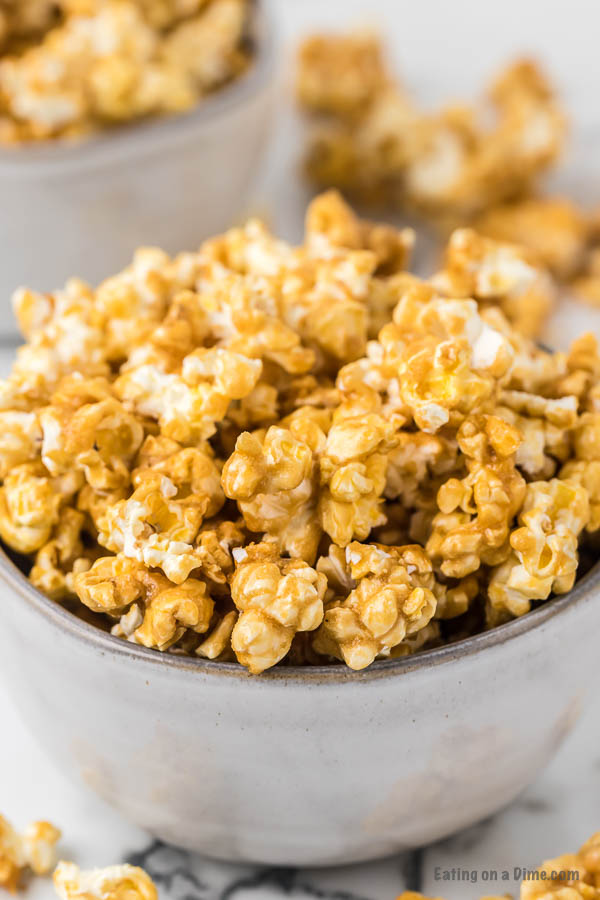 Close up image of caramel popcorn in a white bowl. 