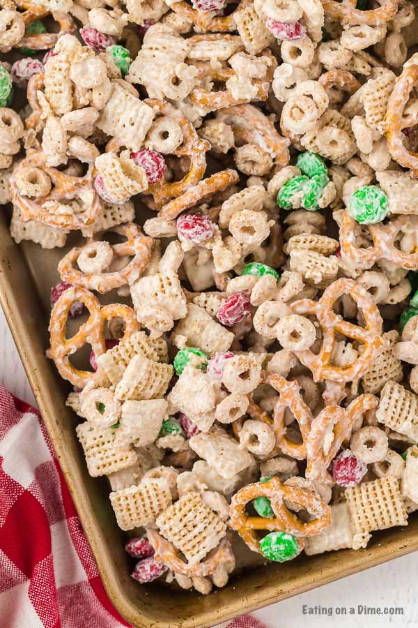 Close up image of Christmas Chex Mix on a cookie sheet. 