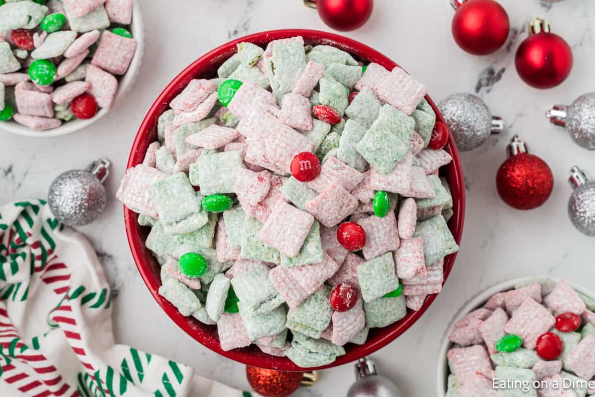 Christmas Chex Mix in a bowl with holiday bulbs on the side