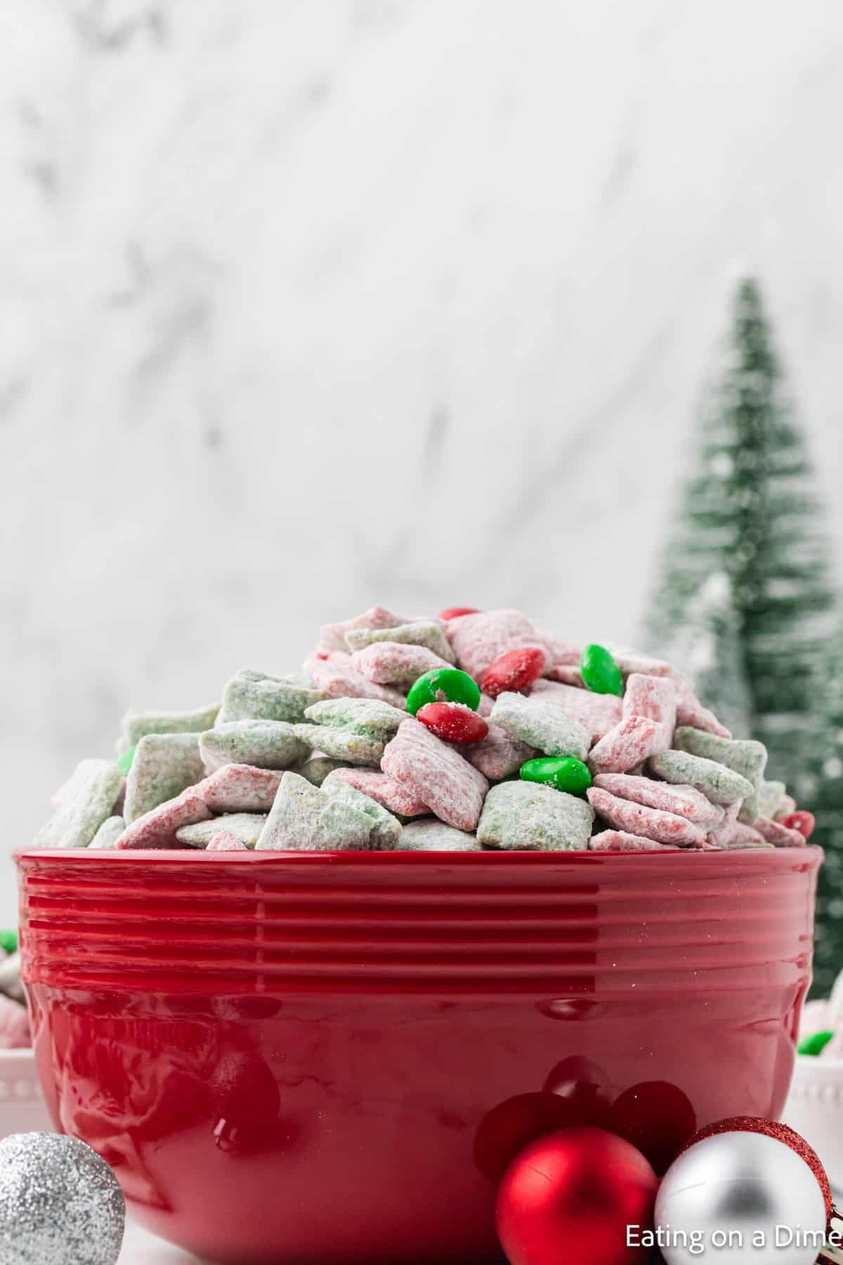 Christmas Puppy Chow in a bowl topped with Red and Green M&Ms