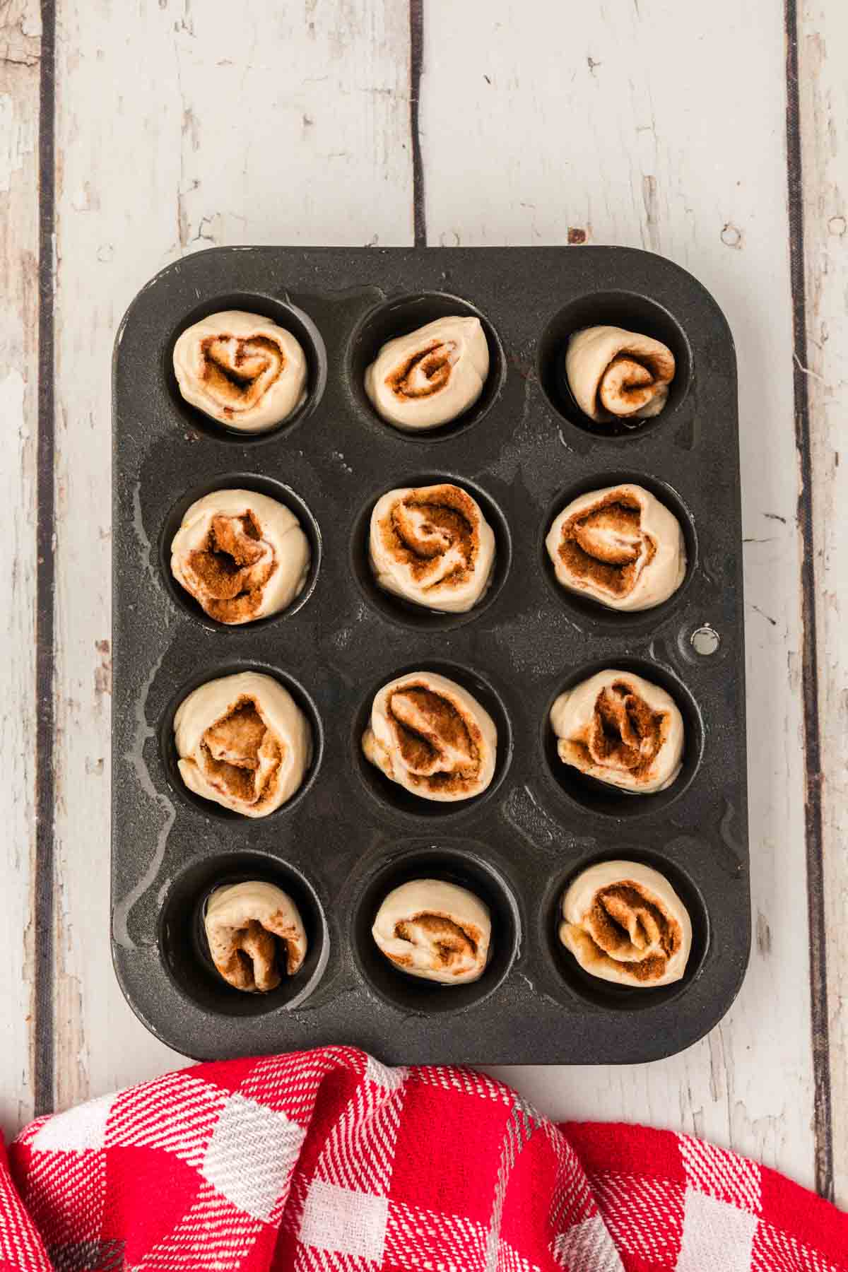 Placing the cinnamon rolls in the muffin tin