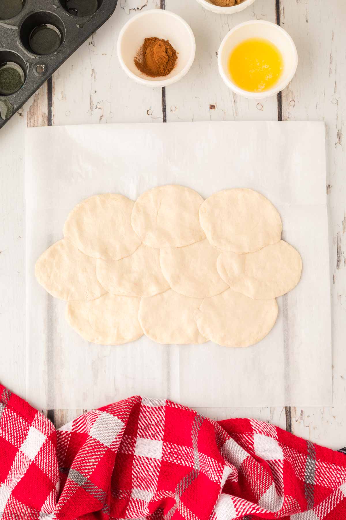 Pressing the biscuits flat on parchment paper