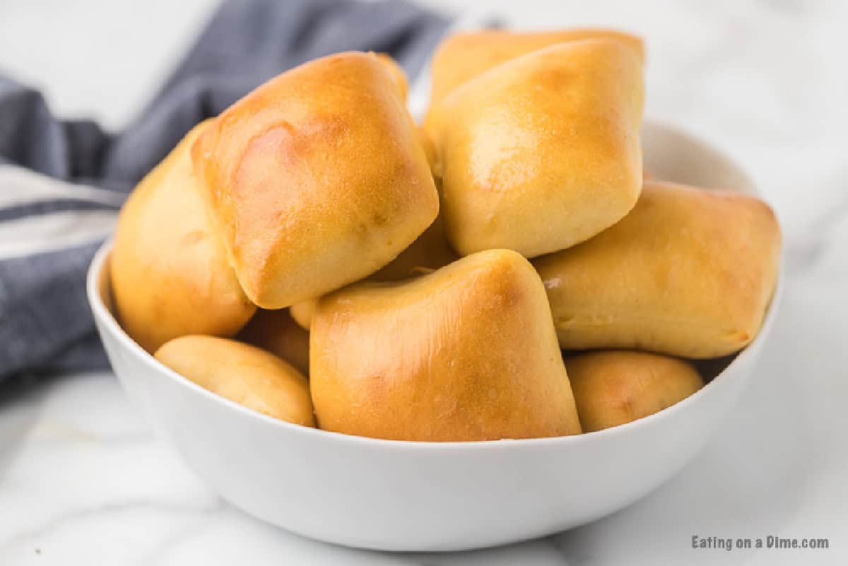 Homemade Texas Roadhouse Rolls stacked in a white bowl.