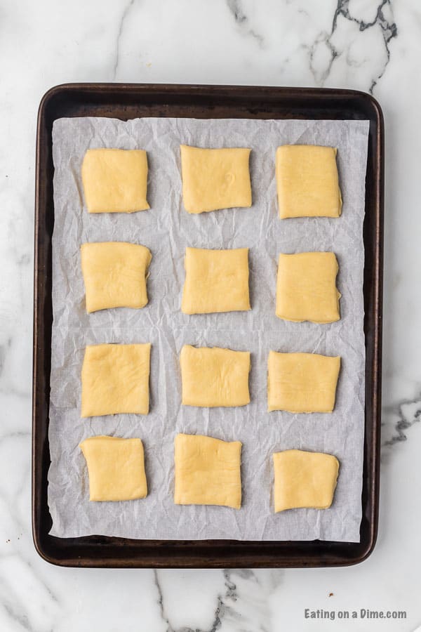 Cut dough into square pieces and place on a baking sheet