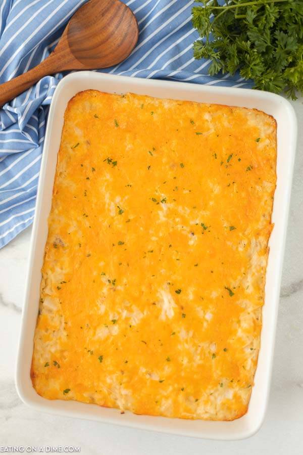 Overview of the cooked cheesy potato casserole topped with chopped parsely 