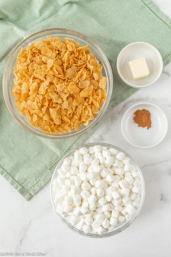 Close up image of ingredients for cornflakes - marshmallow, cornflakes, cinnamon, and butter. 