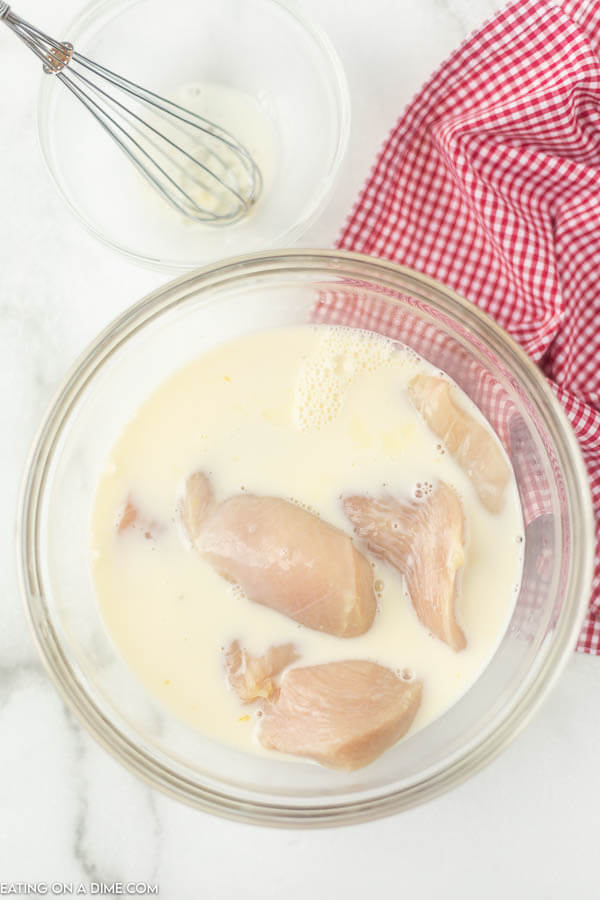 Large bowl with chicken soaking in milk. 