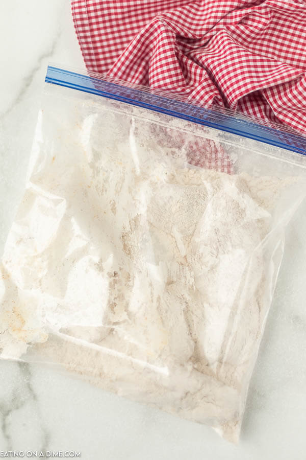 Large ziplock bag with chicken coated in flour. 