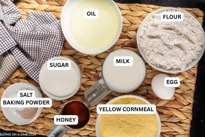 Ingredients for recipe - oil, flour, milk, sugar, salt, baking powder, honey, yellow cornmeal, egg. 
