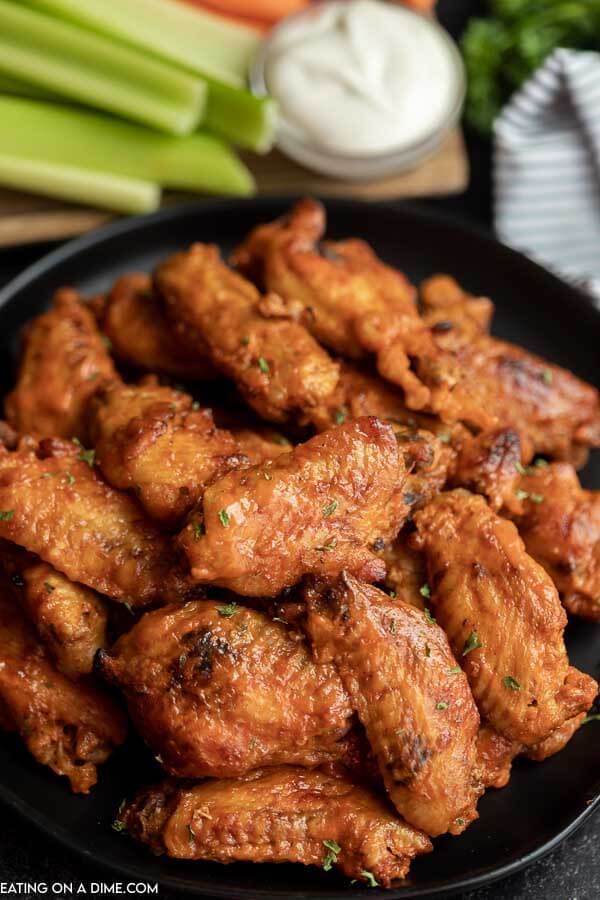 Platter of chicken wings with celery behind it.