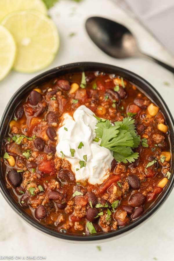 Black bean soup with cilantro topped with sour cream in a bowl. 