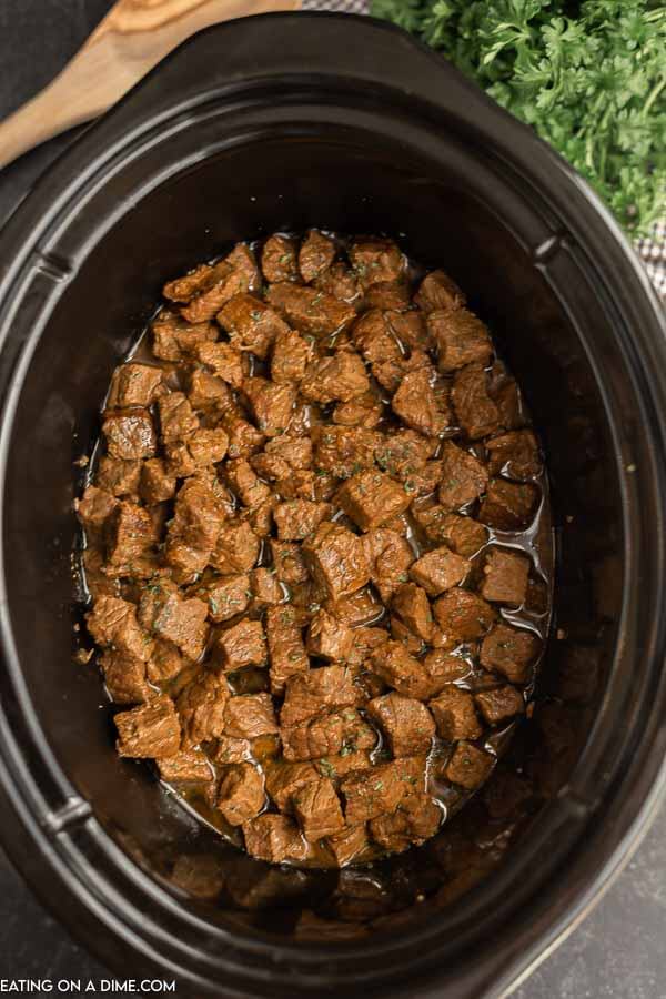 Close up image of steak bites in a crock pot. 