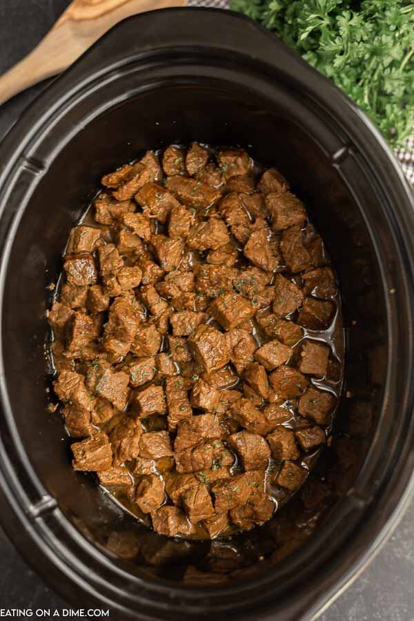 Dinner is a breeze when you make this easy Crock Pot Steak Bites Recipe. The entire family will love keto steak bites. Each bite is tender and delicious! Close up image of steak bites in a crock pot.