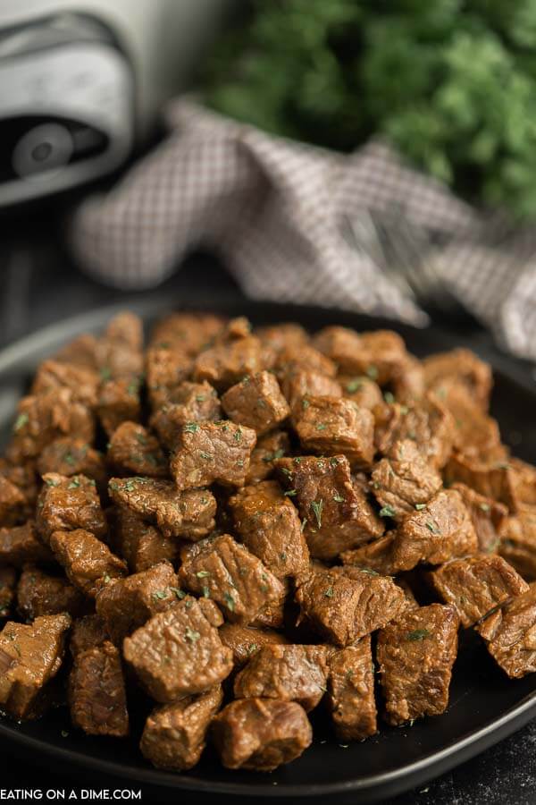 Dinner is a breeze when you make this easy Crock Pot Steak Bites Recipe. The entire family will love keto steak bites. Each bite is tender and delicious! Close up image of steak bites in a black plate.