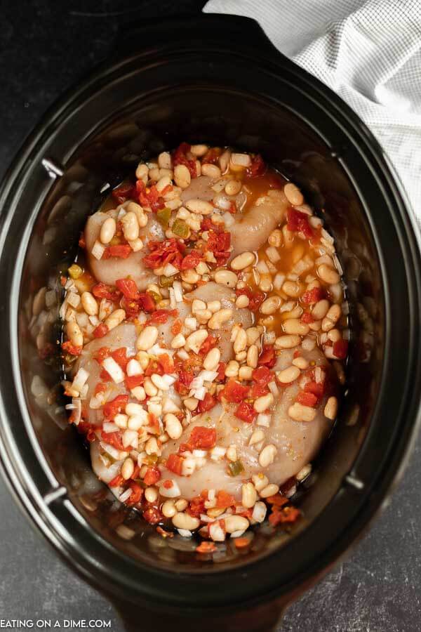 Try Crockpot Chicken Taco Soup when you need a tasty dinner fast. Simply toss all the ingredients in the slow cooker and Taco Chicken Soup will be ready! Close up image of chicken taco in process in the crock pot.