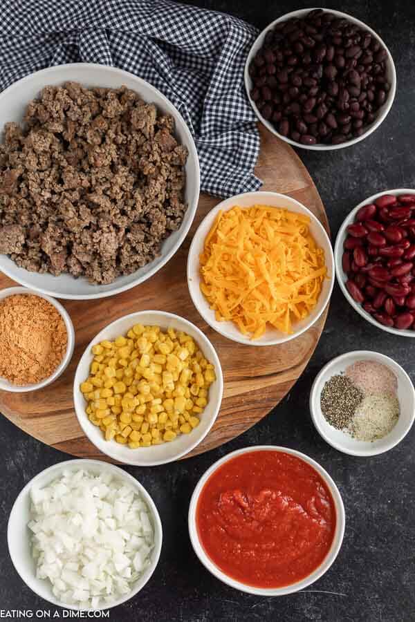 Ingredients needed for taco soup - ground beef, taco seasoning, garlic salt, salt and pepper, onion, frozen corn, black beans, kidney beans, crushed tomatoes, chicken broth, cheddar cheese. 