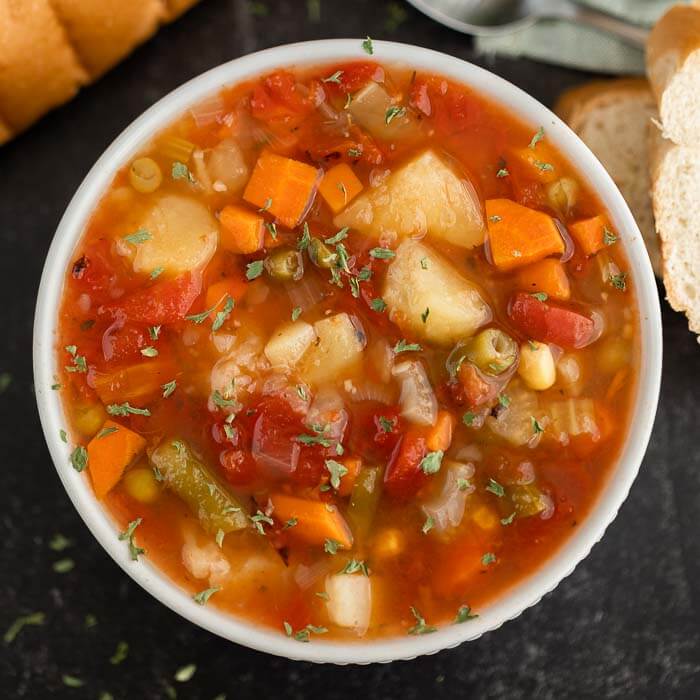 Close up image of vegetable soup in a white bowl. 